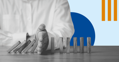 A photograph of a man's hand stopping dominos falling, representing stopping a ransomware attack in its tracks.